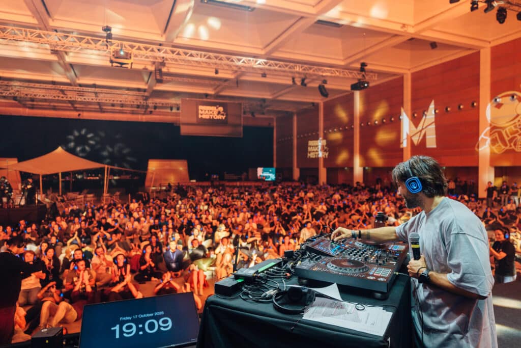DJ avec casque silent disco devant une foule équipée de casques